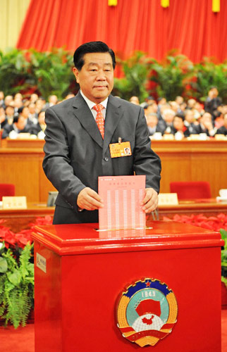 這是全國政協(xié)十一屆一次會議主席團(tuán)會議主持人賈慶林在投票。